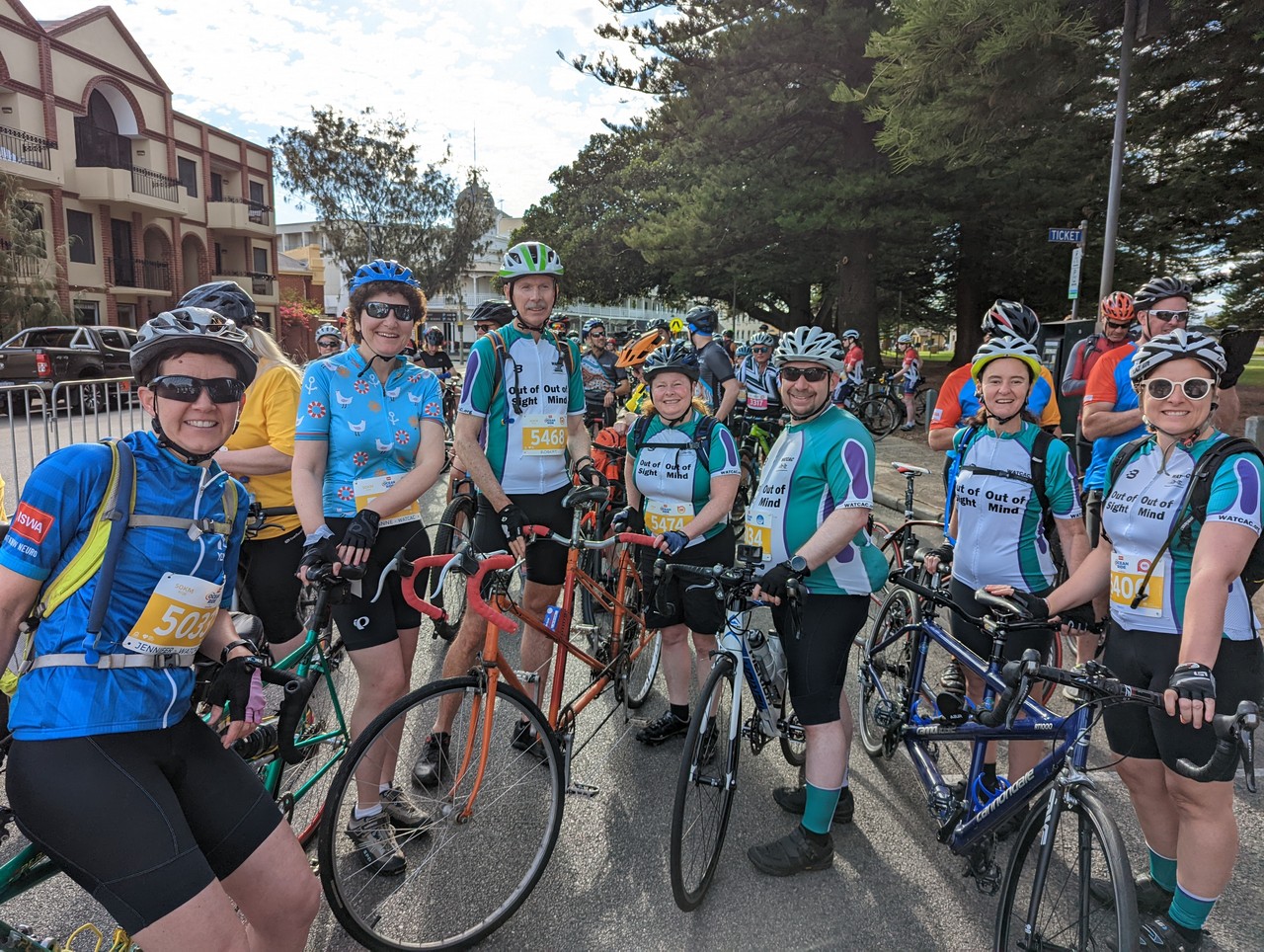 A group of seven WATCAC riders with tandems and a single bike are standing at the start of the 2021 MS Society's community Ocean Ride.