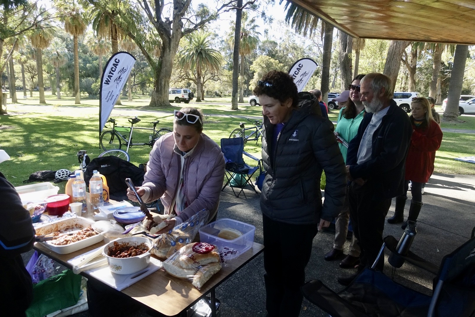 Fuelling up with a delicious filled roll helped keep the winter chills at bay.  The image shows guest lining up for food self service at a table in the picnic area.