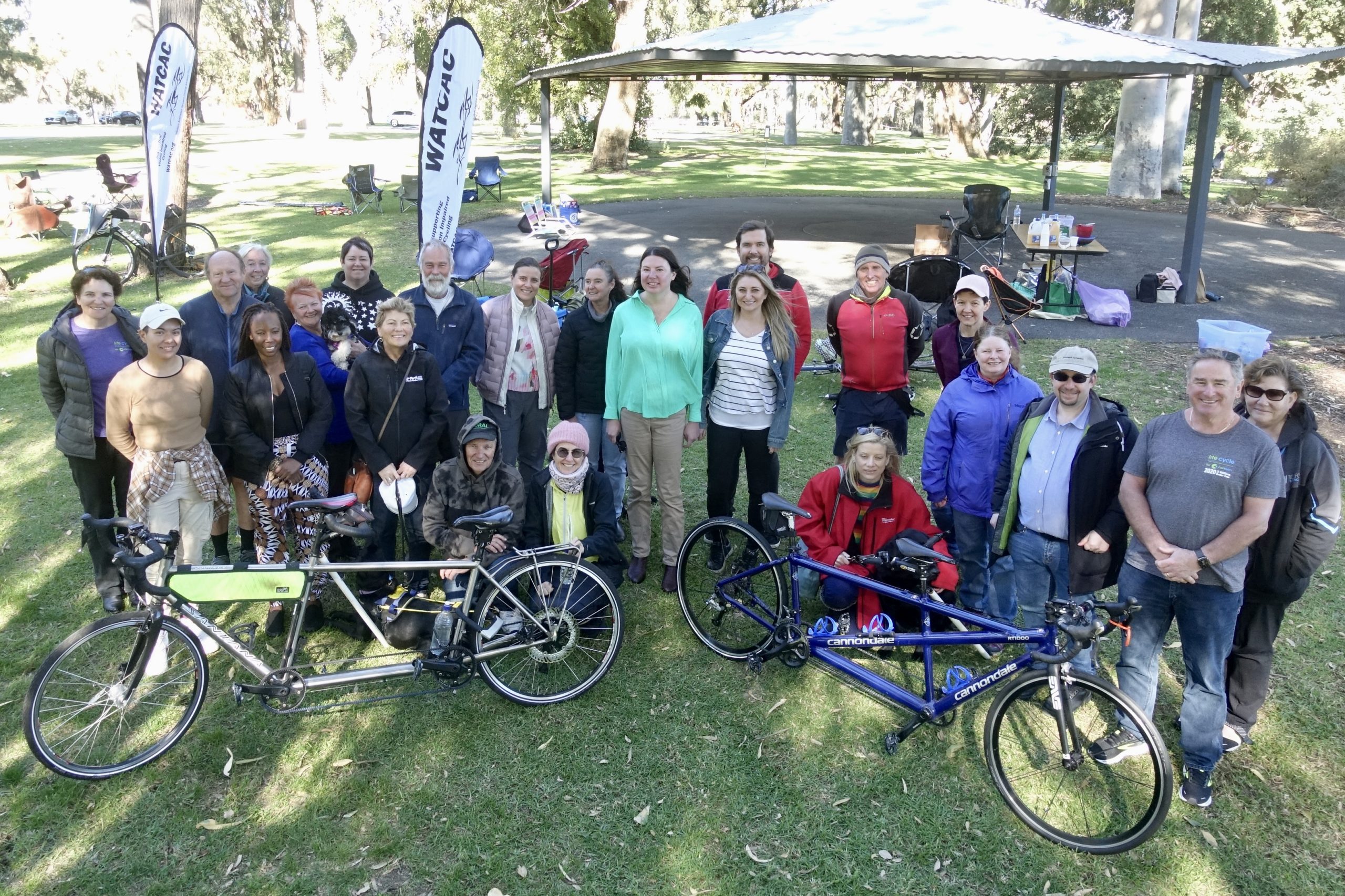 Members and friends gathered for the WATCAC Volunteer Picnic in the scenic backdrop of Kings Park to celebrate the efforts of our members in supporting the Assocation.  The image shows a group of people gathered around two tandem bicycles with WATCAC banners fluttering in the cool winter breeze.